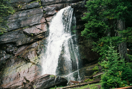 [A wide frothy cascade of water goes dow a rocky hillside.]